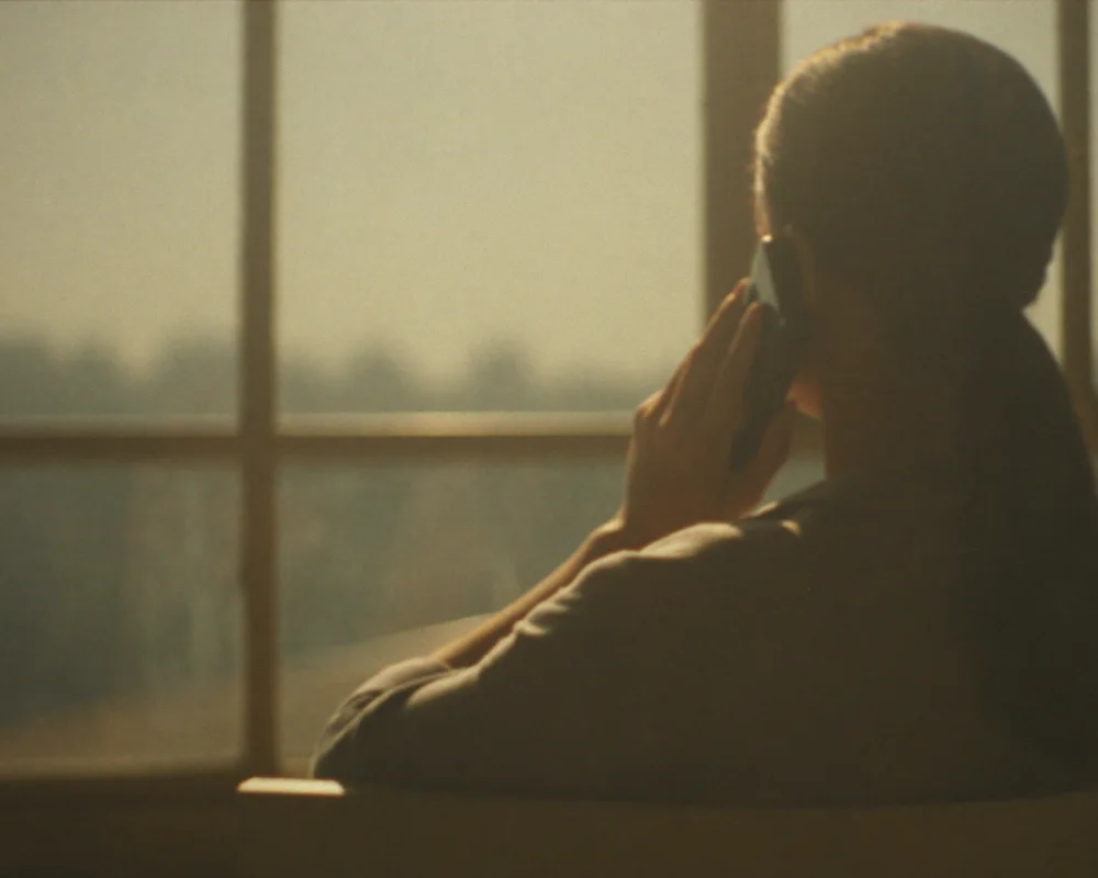 A phone resting on a warm table by a sunlit window