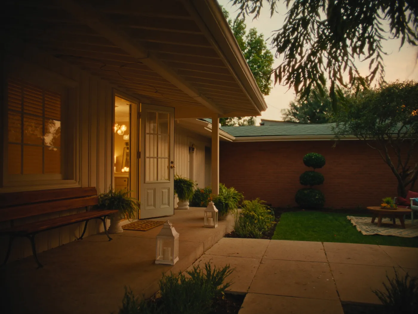 The welcoming front porch of the home at golden hour, door open